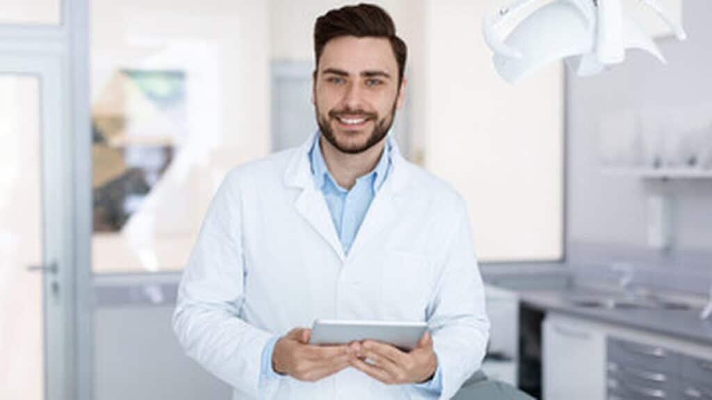 A dentist using a tablet to submit cases through the EvoDOCTOR portal