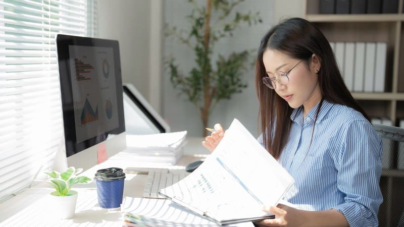Lab owner at a desk with a monitor and a stack of reports